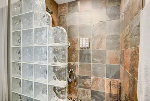 Tiled walk-in shower with glass block wall at a rental property we manage in Las Vegas, Nevada