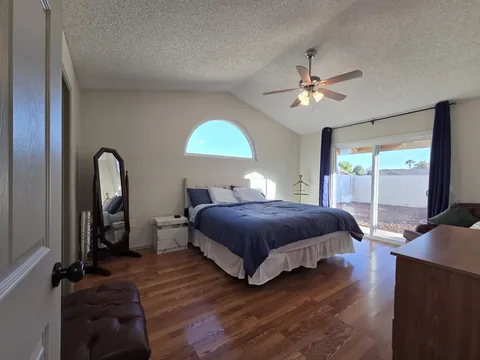 Bedroom with hardwood flooring and arched window at a rental property we manage in Chandler, Arizona