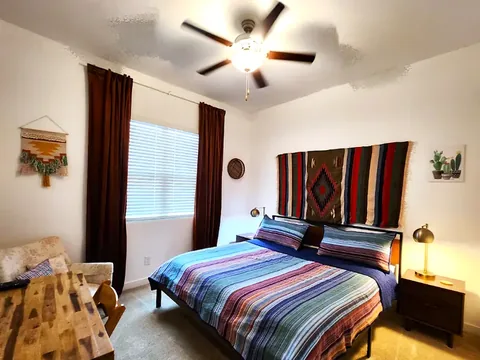 Bedroom with woven wall hanging and warm lighting at a rental property we manage in Phoenix, Arizona