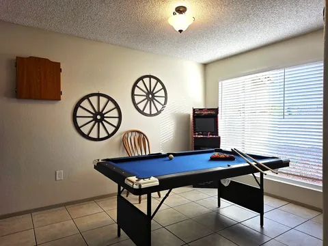 Game room with pool table and arcade machine at a rental property we manage in Chandler, Arizona