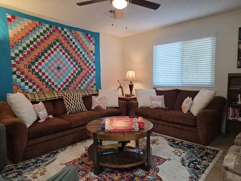 Living room with two sofas and a large area rug at a rental property we manage in Chandler, Arizona