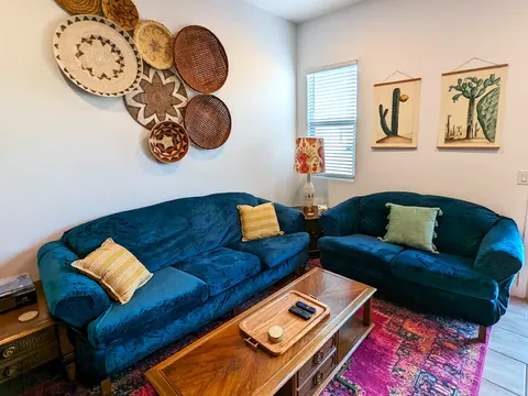 Living room with teal sofa and southwestern decor at a rental property we manage in Phoenix, Arizona